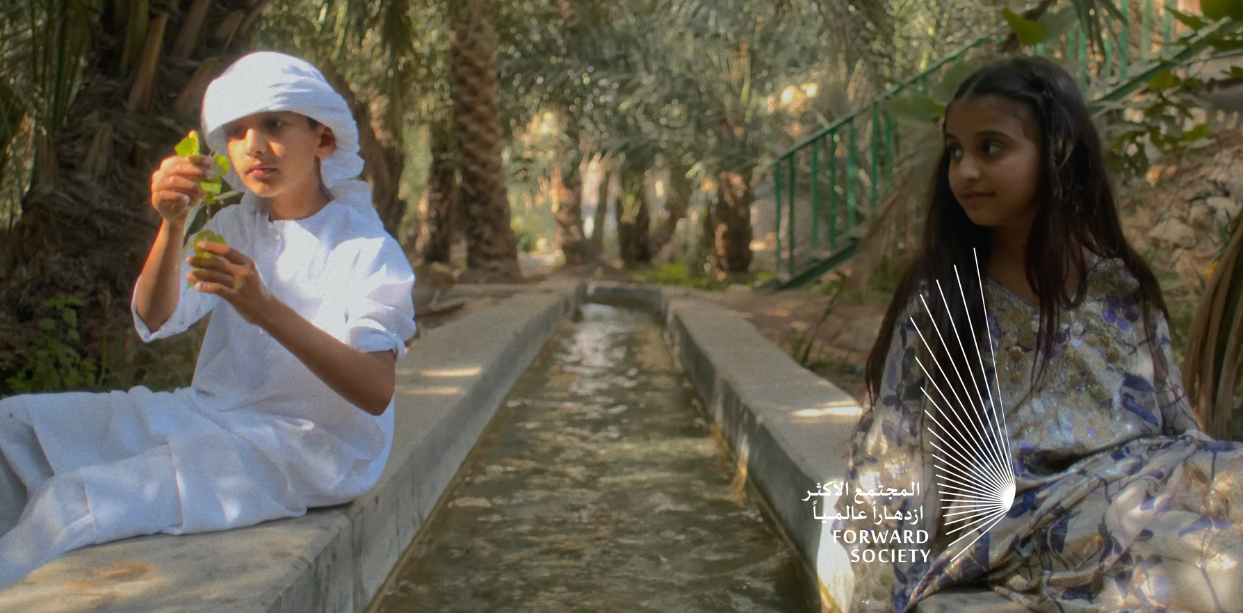 An image of a boy and a girl in nature (an oasis)